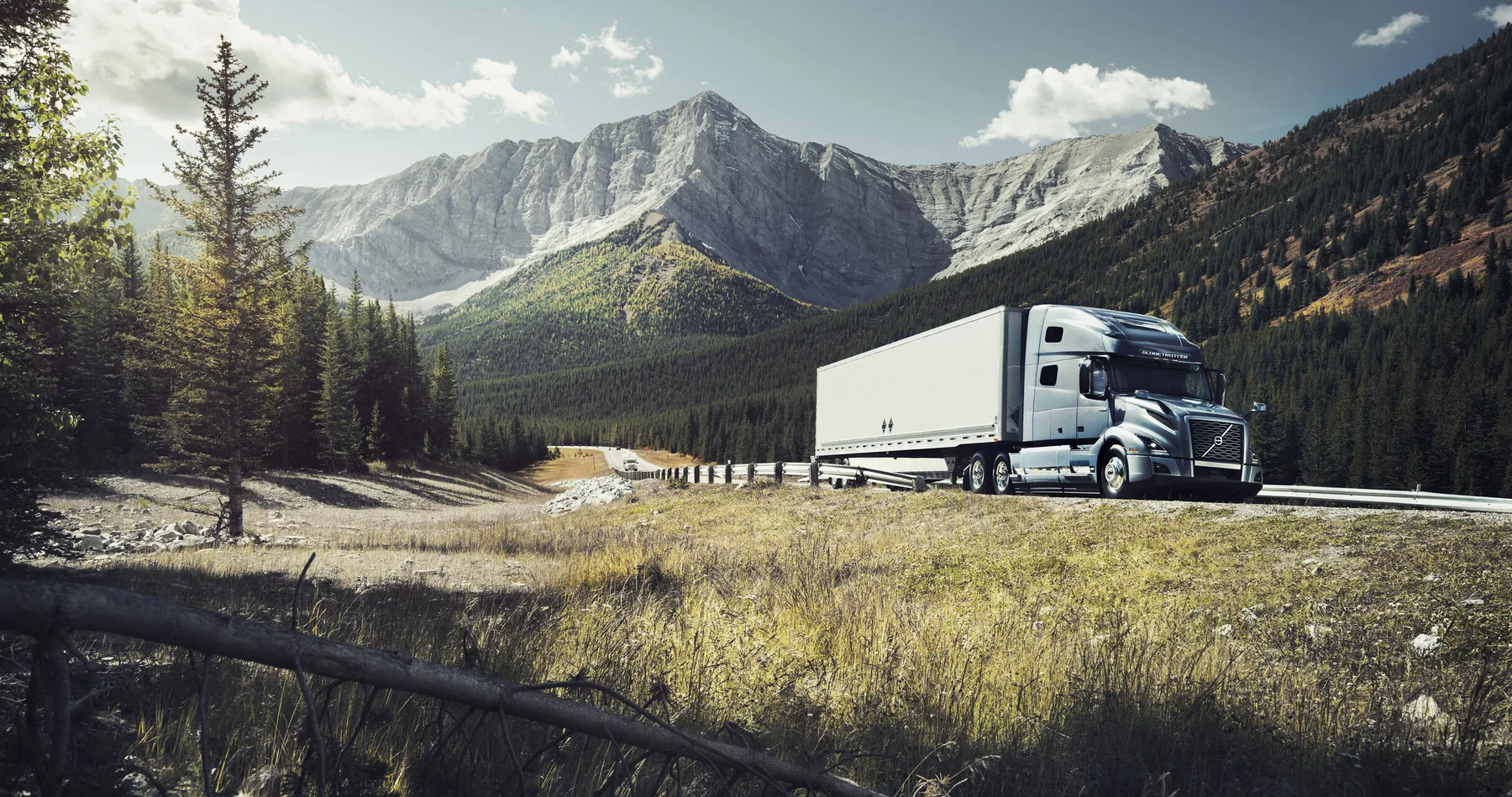 Volvo tractor-trailer traveling through a mountain corridor
